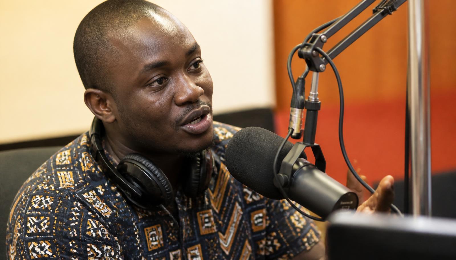 Presenter speaking into a microphone during a live business discussion